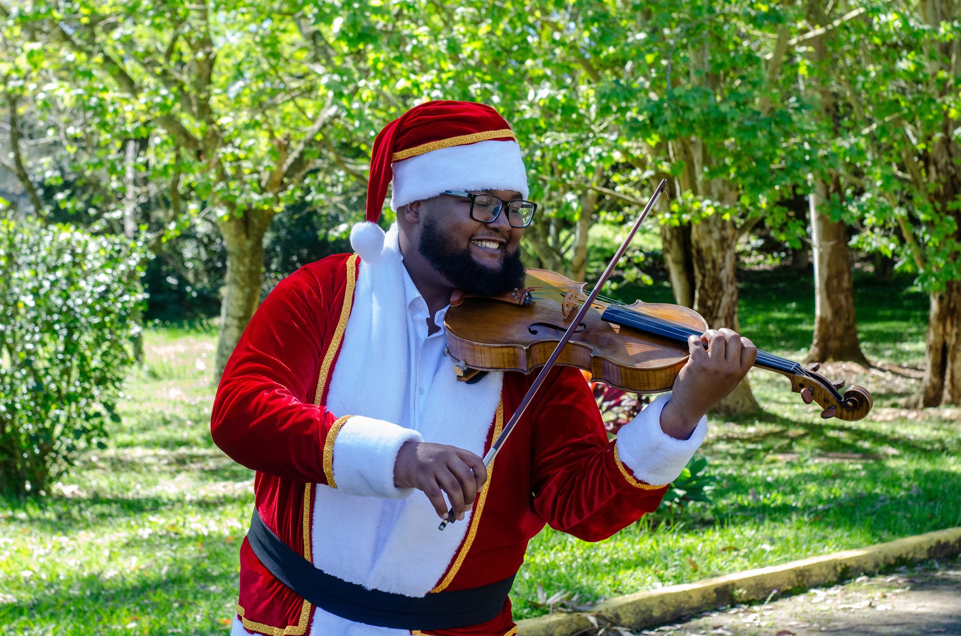 Papai Noel violista da Trupe de Natal em serenata